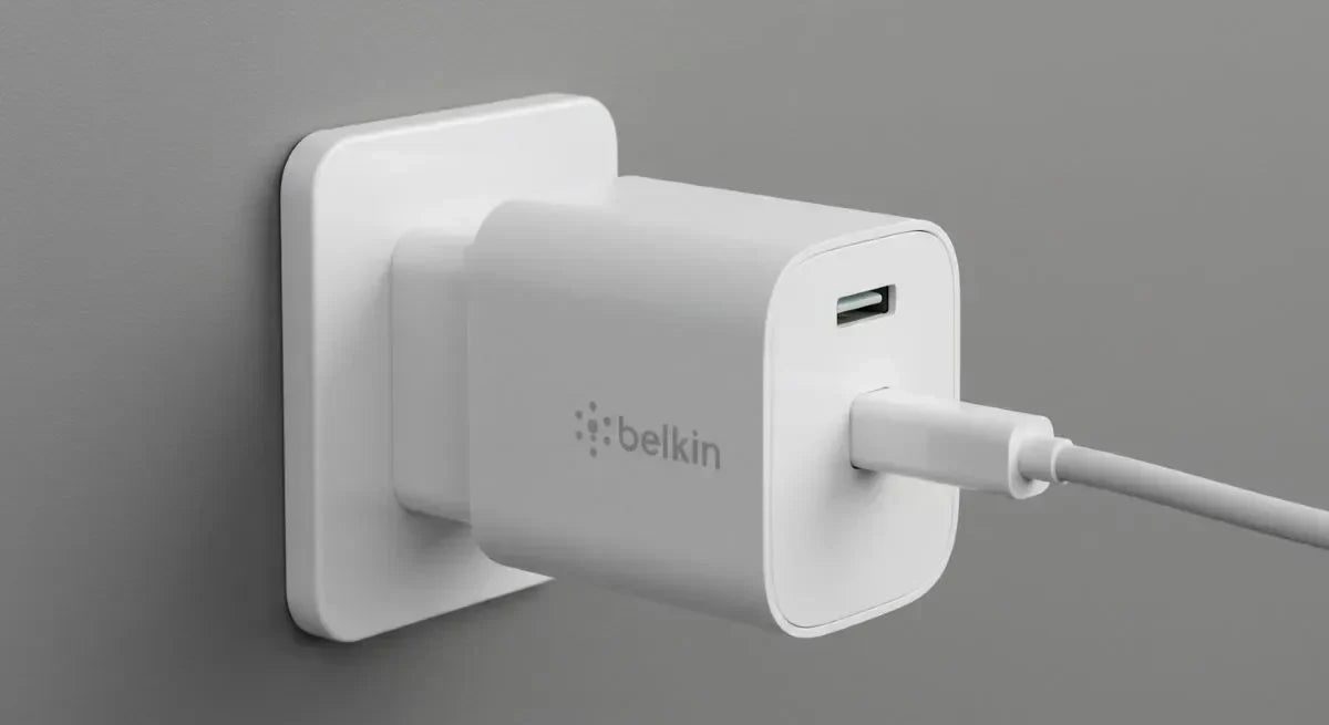 Belkin white USB charger plugged into a wall outlet.